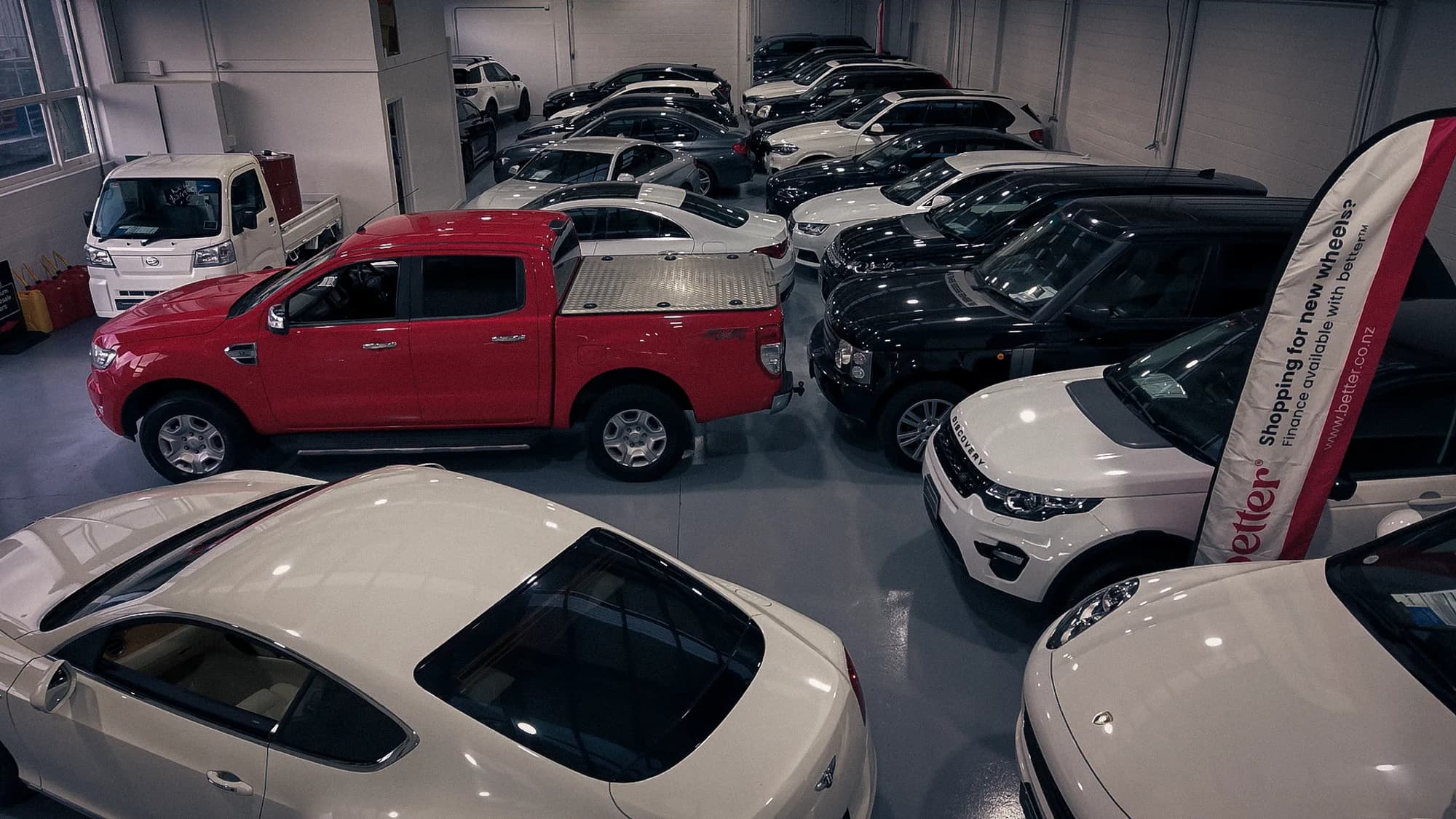 Ute, SUVs and sedans packed tightly inside the Premium Wholesale Cars indoor showroom